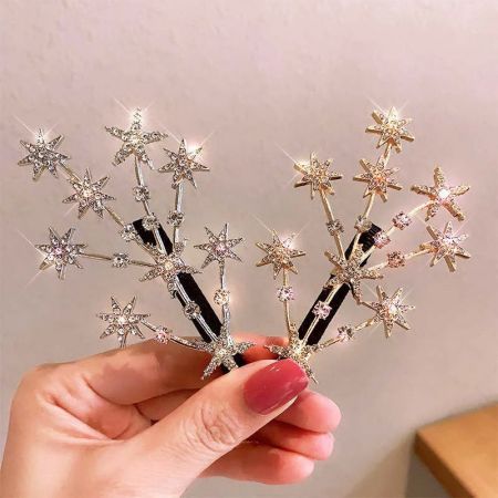 Vista dettagliata delle clip per capelli a forma di stella, in oro e argento, che mostrano i dettagli intricati dei cristalli.