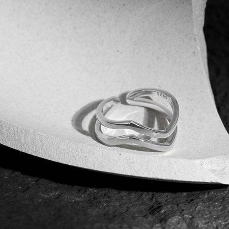 Gros plan détaillé de la bague ondulée en argent sterling 925 avec son design à bande ouverte et ajustable.