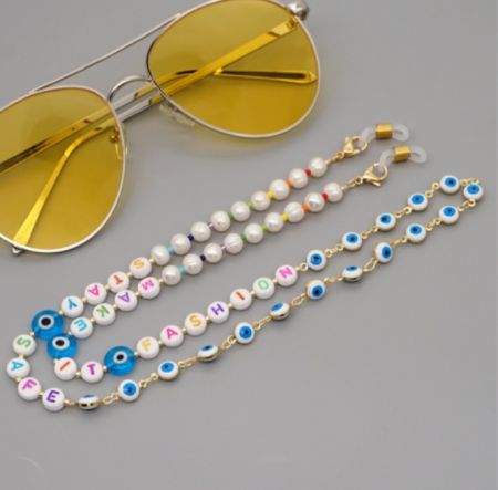 Närbild av Evil Eye glas kedjans intrikata pärlbroderi och guld detaljer.