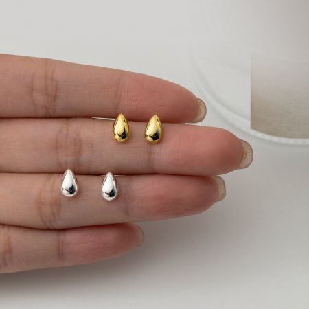 Orecchini a perno a goccia d'acqua lucidi in argento sterling 925 (Set di 5 paia) - Una mano che tiene quattro orecchini a perno a goccia d'acqua in argento sterling 925, due con finitura oro lucido e due con finitura argento lucido, mostrando la qualità e le opzioni di colore del prodotto.