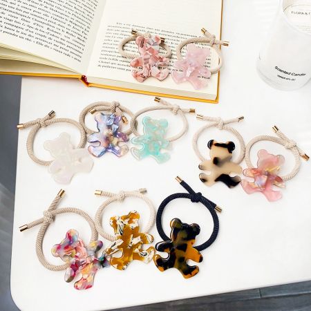 Bear Shaped Acetate Charm Elastic Hair Tie Bands - A collection of colorful elastic hair tie bands, each adorned with a unique bear-shaped charm made from acetate, displayed on a neutral background.