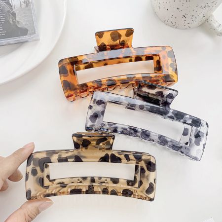 Four large hair claw clips in assorted tortoiseshell patterns.
