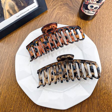 Two large tortoiseshell hair clips displayed on a white surface.
