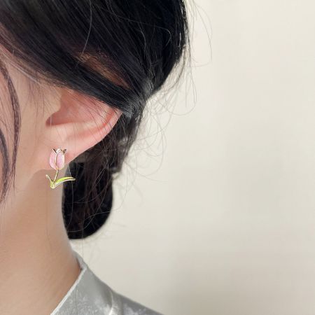 Modèle portant la petite boucle d'oreille en forme de tulipe pour montrer l'échelle et le style.