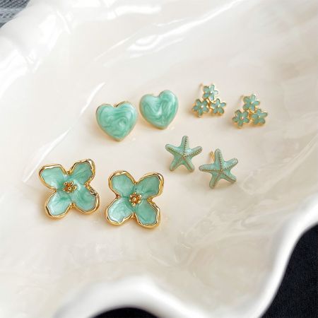 14K Gold Plated Mint Green Enamel Women's Daily Stud Earrings - A collection of five pairs of 14k gold-plated stud earrings with mint-green enamel, featuring flower, heart, and starfish designs.