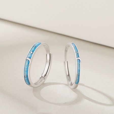 Set di anelli di coppia regolabili in argento sterling 925 con smalto a forma di stella e luna. - Una coppia di anelli di coppia regolabili in argento sterling 925 con un design celestiale di stelle e lune evidenziato da smalto blu.