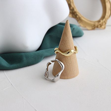 Set di 5 anelli regolabili minimalisti in argento sterling 925 gioielli all'ingrosso. - Un set di anelli regolabili minimalisti sia in finitura placcata in oro 18K che in argento sterling 925, con un design moderno a banda aperta ondulata, esposto su un supporto di legno.