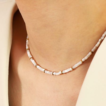 Waterdichte Roestvrijstalen Witte Schelpenkralen Choker Ketting (Set van 5) - Een model dat de elegante waterdichte roestvrijstalen ketting met witte schelpenkralen en een gouden afwerking toont.