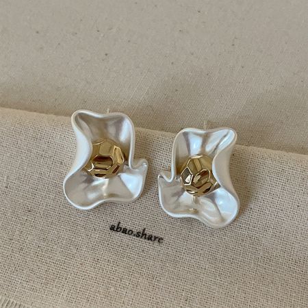 Vista dettagliata degli orecchini a petalo in oro opaco, che evidenziano il design floreale scolpito.