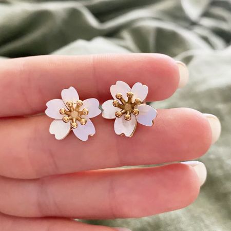 Close-up of the mother of pearl flower stud earrings with gold centers.