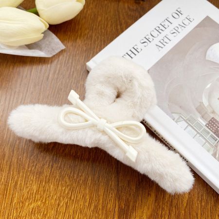 かわいいウサギの形にスタイリングされた白いふわふわのヘアクリップで、遊び心のあるルックにぴったり。