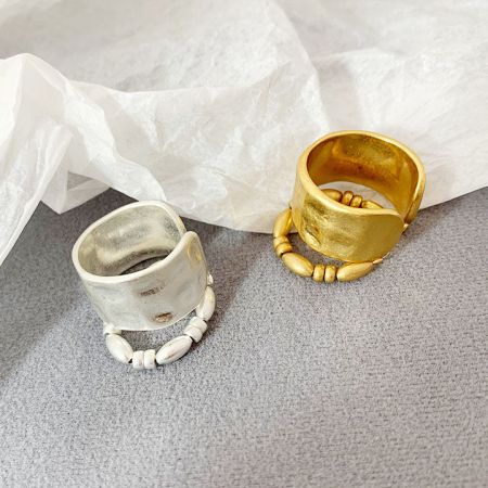 Bague ouverte en laiton à deux couches de style français avec perles - Une paire d'anneaux ouverts à deux couches de style français en finitions or et argent, avec des détails de perles élégants sur un fond blanc.