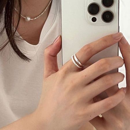 L'anneau en argent à double bande stylisé sur une main, mettant en valeur son look élégant pour un port quotidien.