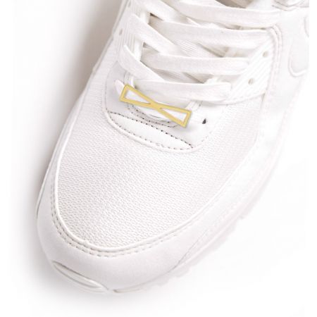 The Bow Shoe Charm elegantly attached to the laces of a white sneaker, demonstrating its application.