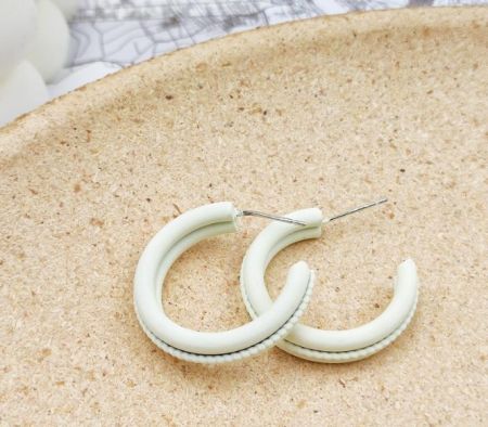 Stylish white hoop earrings featuring a unique textured enamel surface.