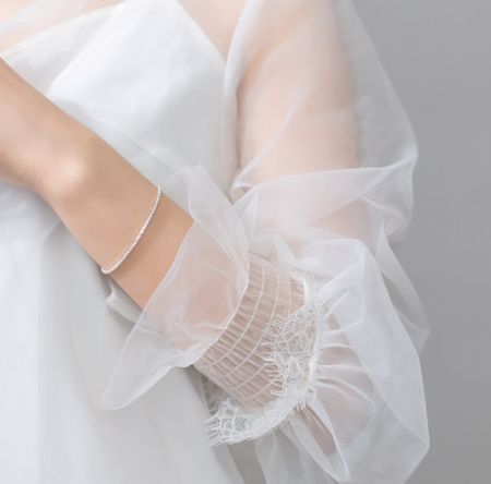 Zijaanzicht van de sterling zilveren glanzende armband op de arm van een vrouw.