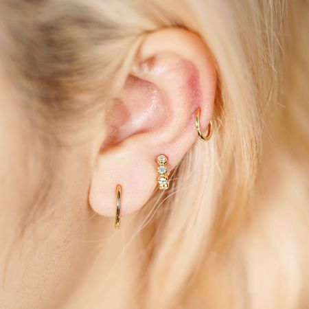 Livsstilsbild som visar hur de sterlingsilver hoop örhängena kan stylas med andra piercingar.