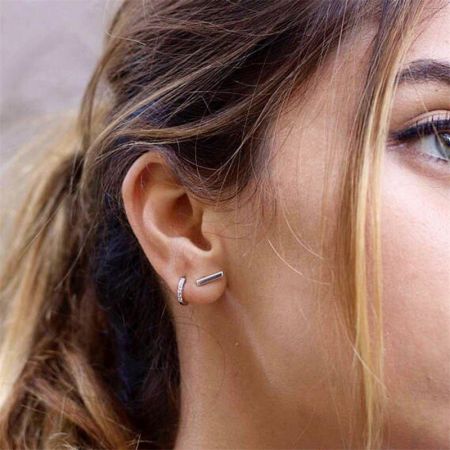 Un modello che indossa gli orecchini a cerchio in argento sterling con zirconia micro-inserita per mostrare la loro dimensione e vestibilità.