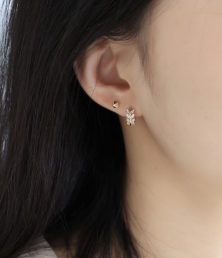 Modello che indossa gli orecchini a foglia a stella in argento sterling 925 per mostrare scala e stile.