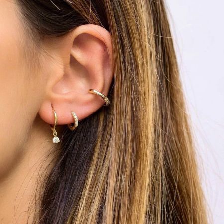 Immagine di lifestyle che mostra gli orecchini a cerchio in zirconia dorata abbinati ad altri pezzi per un look alla moda.