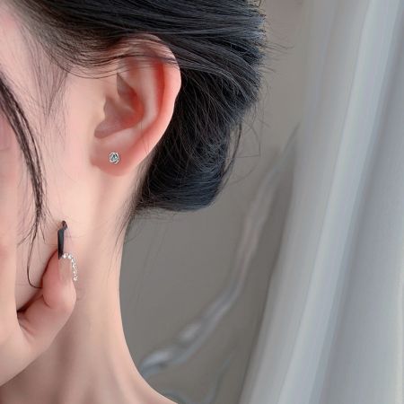 Un modello che indossa gli orecchini a perno a forma di rosa per mostrare la loro dimensione e stile.