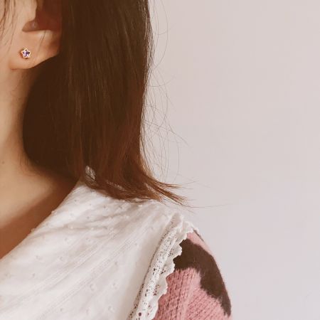 Immagine di lifestyle di un modello che indossa gli orecchini a stella come parte di un outfit chic.