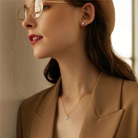 Modèle portant le collier et les boucles d'oreilles en zircon cœur doré.