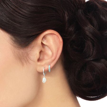 Close-up view of the baroque pearl hoop dangle earrings on a model, emphasizing the texture and shine of the pearl.