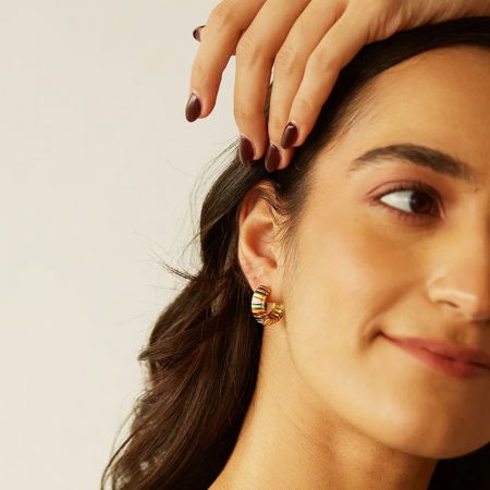 Model wearing the vibrant enamel rainbow chunky hoop earrings, showcasing their stylish look.
