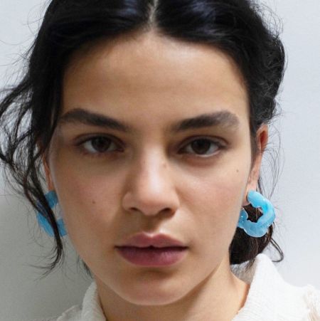 Model showcasing the light blue irregular ruffle resin earrings.