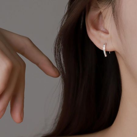 Modello che mostra la vestibilità elegante degli orecchini a gancio in argento sterling 925 con CZ.