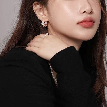 세련된 룩을 위해 스타 후프 귀걸이의 스털링 실버 버전을 선보이는 모델.