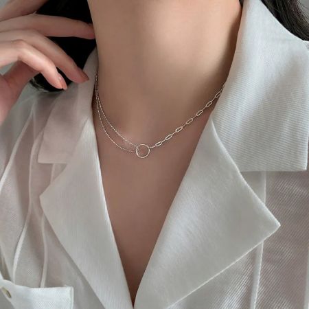 Modèle portant le collier pendentif en cercle argenté à double couche asymétrique pour mettre en valeur son ajustement élégant.