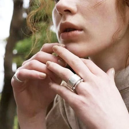 Toma detallada del anillo de plata de dos capas en el dedo de una mujer.