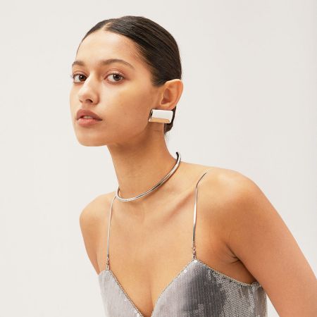 A stylish model showcasing the silver rectangular earrings as part of a complete fashion look.