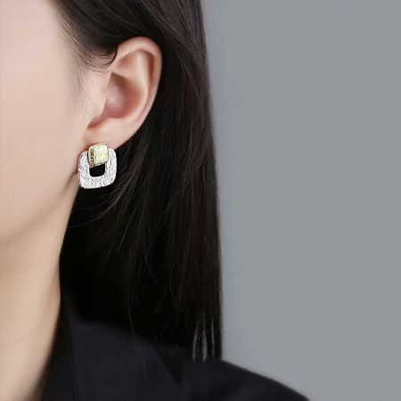 Orecchini a bottone quadrati cavi geometrici bicolore in argento sterling 925 (5 paia) - Un primo piano di una donna che indossa l'orecchino a bottone quadrato cavo geometrico bicolore in argento sterling 925, evidenziando il suo design elegante.