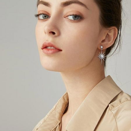 Imagen de estilo de vida de una mujer usando los pendientes de destellos, demostrando su elegante caída y brillo.