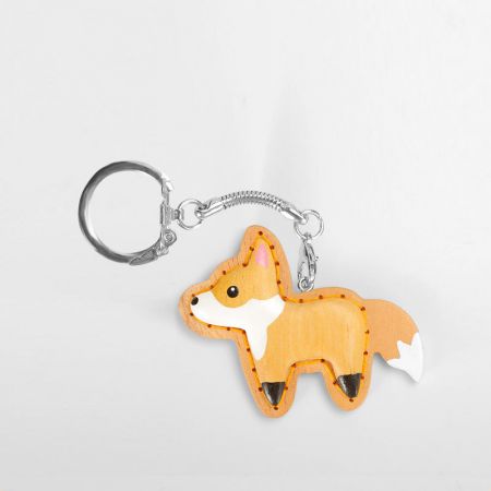 Detailed close-up of a hand-carved wooden fox keychain with PU leather accents.