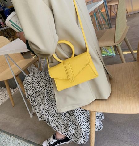 Close-up of the yellow version of the PU leather shoulder bag, highlighting its texture and color.