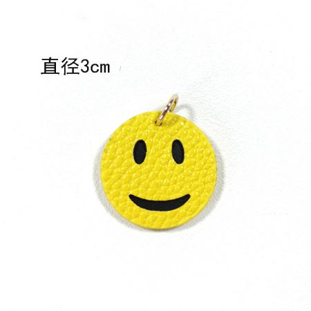 Gros plan du charme en cuir PU en forme de smiley jaune