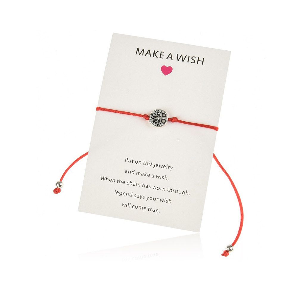 Ett "Make a Wish" Tree of Life-armband med en livlig röd sladd och en detaljerad silverberlock, som visas på dess inspirerande bakkort.