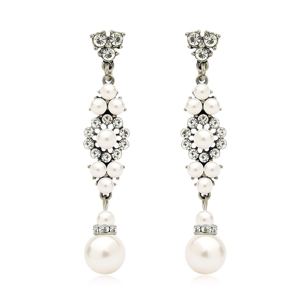 Pendientes de novia de Old Hollywood (JRE-019) con una parte superior decorativa de plata con cristales transparentes y una gran perla blanca, sobre un fondo blanco.