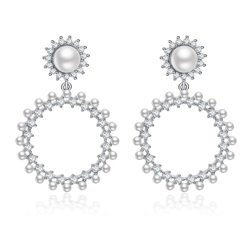 Une paire de longues boucles d'oreilles rondes Show Love avec un design sunburst, avec des perles et des zircons cubiques dans une monture plaquée rhodium.