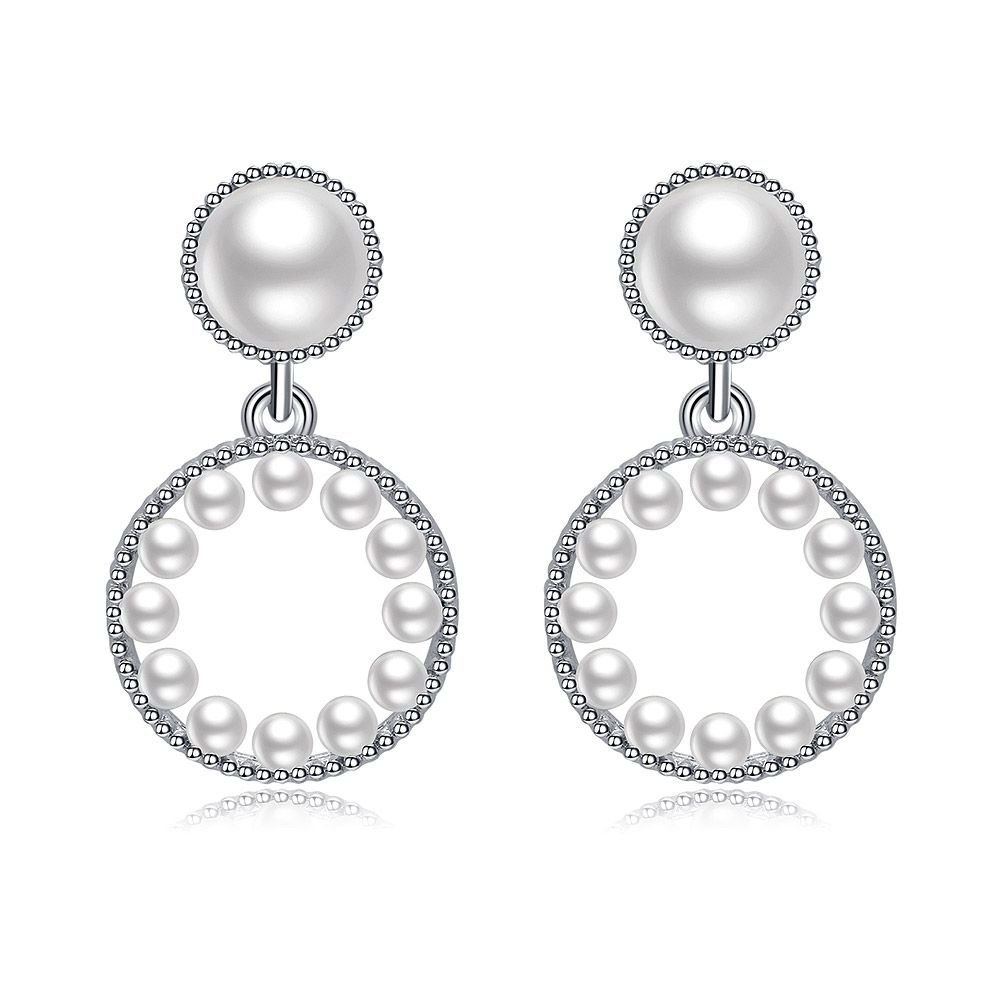 Gros plan des boucles d'oreilles Pearly Baby, mettant en valeur le support en laiton plaqué rhodium avec des zirconiums cubiques blancs et des perles en plastique élégantes.