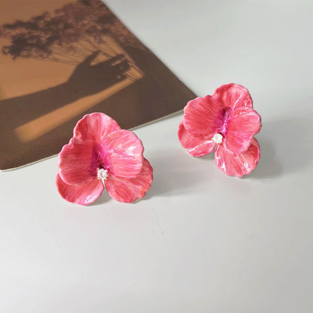 金仕上げの真鍮で作られた、きらめくジルコンの中心を持つエナメルピンク3D花びらイヤリングのペア。
