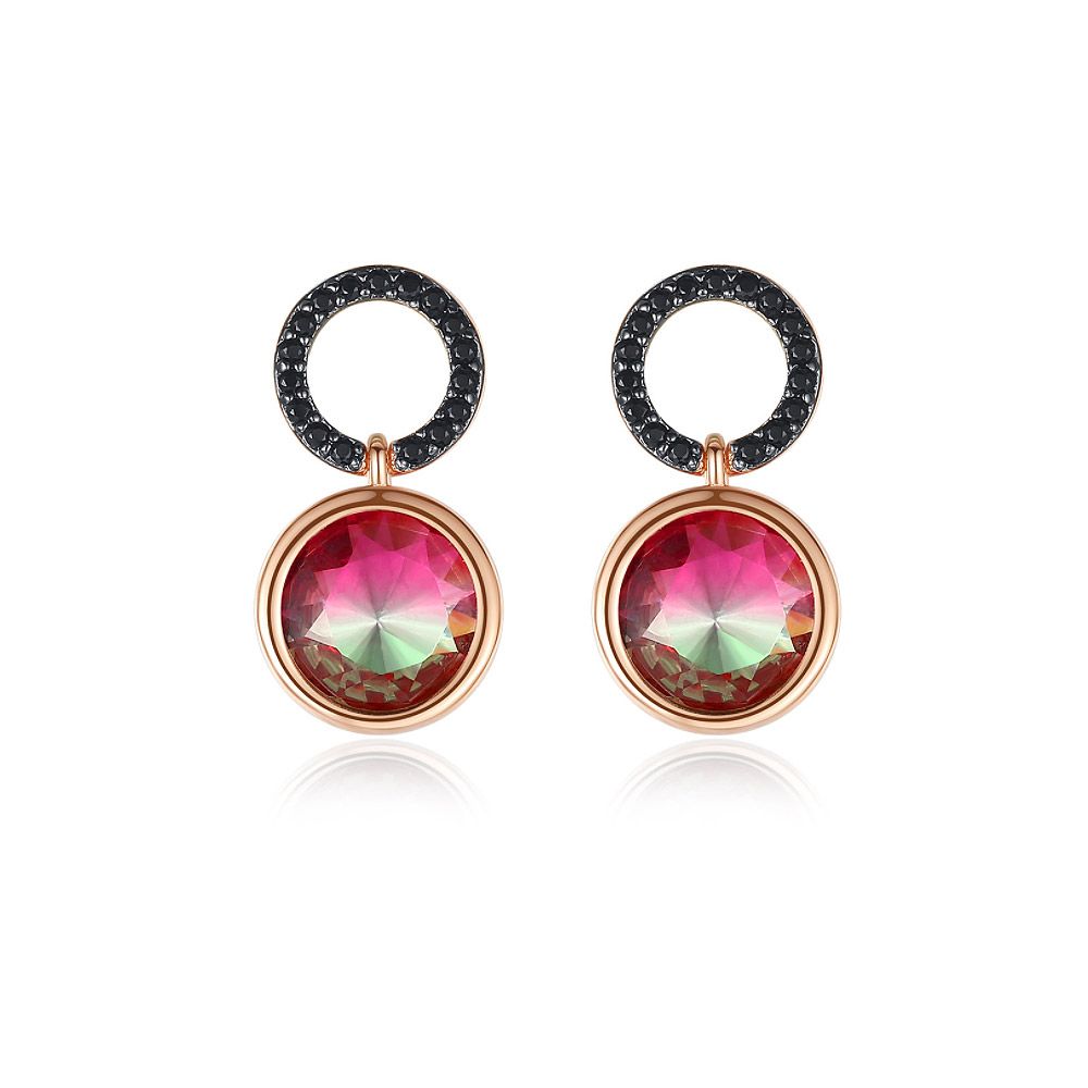 Un gros plan des boucles d'oreilles en cercle avec émail rouge, montrant le plaquage en or rose complexe, le verre rouge vibrant et les cristaux de zircon cubique noir étincelants.