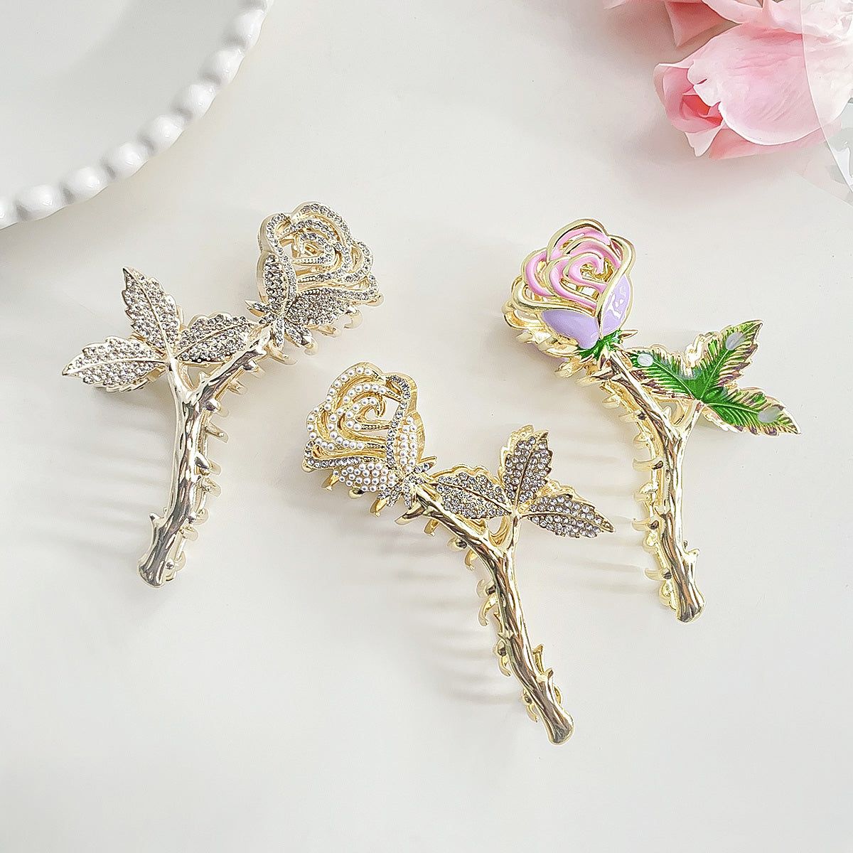 A set of three elegant rose flower hair claw clips in various metallic finishes, showcasing their intricate floral design.