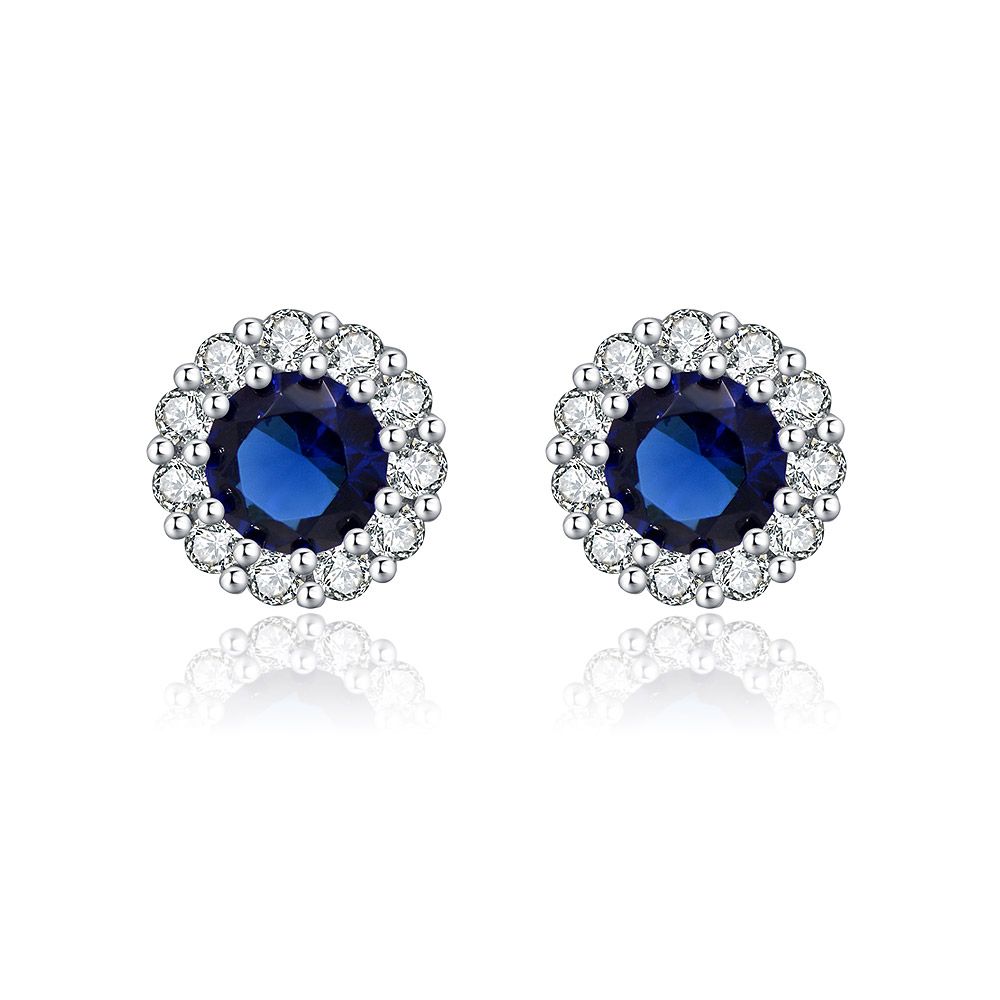 A close-up view of the Rhodium Montana Stud Earring, showcasing the deep blue Montana glass stone encircled by a brilliant halo of white cubic zirconia, set in rhodium-plated brass.