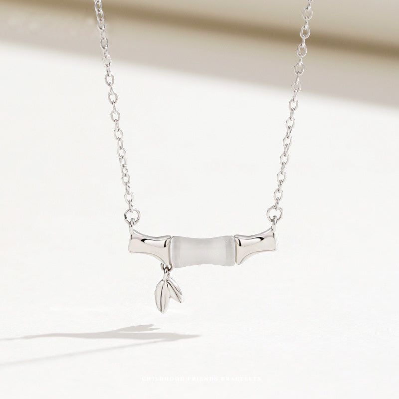 A close-up of a 925 sterling silver necklace from the set, featuring an elegant bamboo-inspired pendant with a white opal stone.