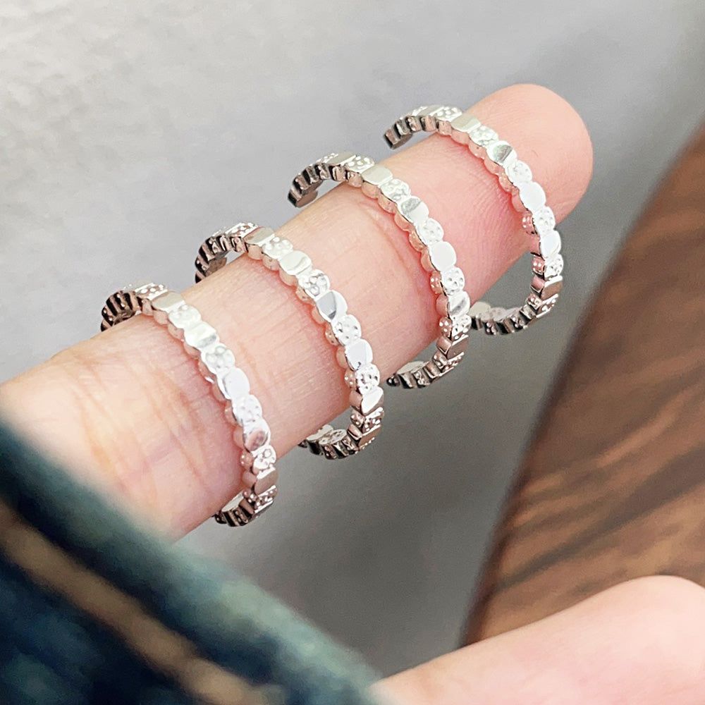 A close-up of a hand wearing a set of three stylish 925 sterling silver open rings with a geometric bead design, part of a wholesale set.